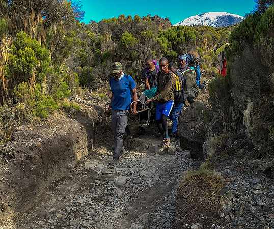 an unfortunate climber from another group being carried down on the iron cart